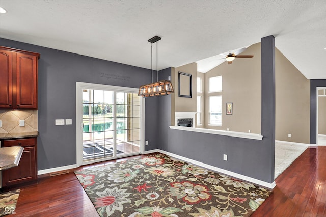 10267 Ranford Blvd, Fishers, IN 46040 - dining area featuring dark wood finished floors, ceiling fan, healthy amount of natural light, vaulted ceiling, and a fireplace