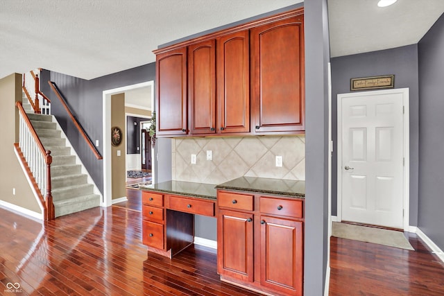 10267 Ranford Blvd, Fishers, IN 46040 - kitchen featuring dark wood finished floors, tasteful backsplash, reddish brown cabinets, dark stone counters, and recessed lighting