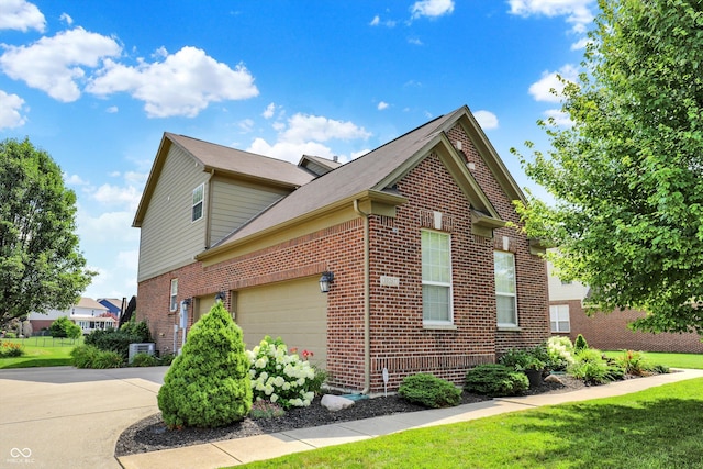 10267 Ranford Blvd, Fishers, IN 46040 - view of side of home featuring brick siding, driveway, a yard, and a garage