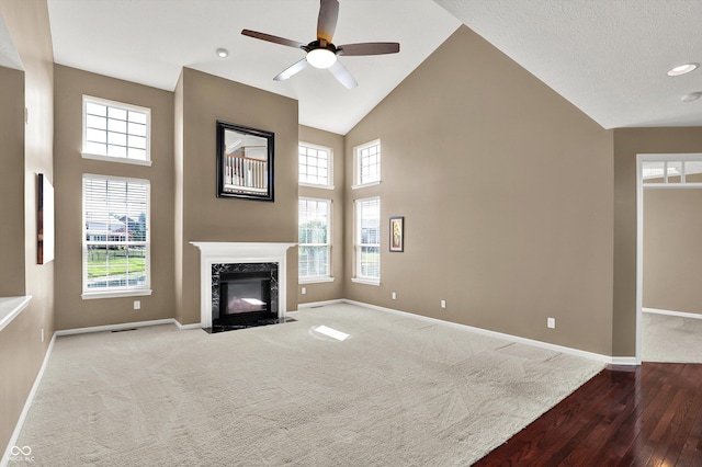 10267 Ranford Blvd, Fishers, IN 46040 - unfurnished living room featuring wood finished floors, a ceiling fan, plenty of natural light, a high ceiling, and a premium fireplace