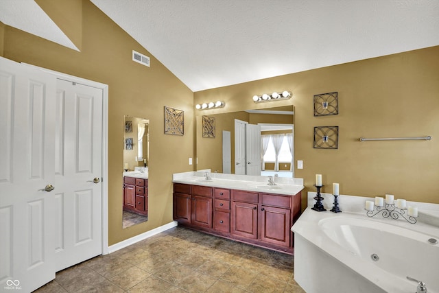 10267 Ranford Blvd, Fishers, IN 46040 - full bathroom with double vanity, a jetted tub, high vaulted ceiling, and a textured ceiling