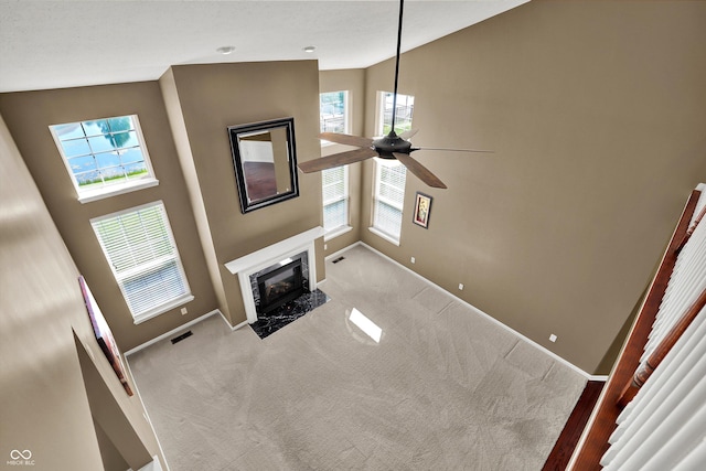 10267 Ranford Blvd, Fishers, IN 46040 - unfurnished living room featuring carpet flooring, a ceiling fan, a premium fireplace, and healthy amount of natural light