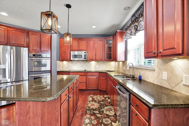10267 Ranford Blvd, Fishers, IN 46040 - kitchen with stainless steel appliances, reddish brown cabinets, a center island, and recessed lighting