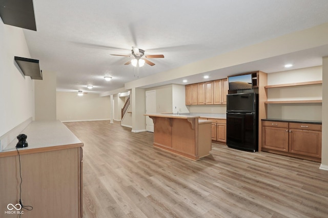 7927 Broadmead Way, Indianapolis, IN 46259 - kitchen featuring freestanding refrigerator, a kitchen bar, open floor plan, light wood finished floors, and light countertops