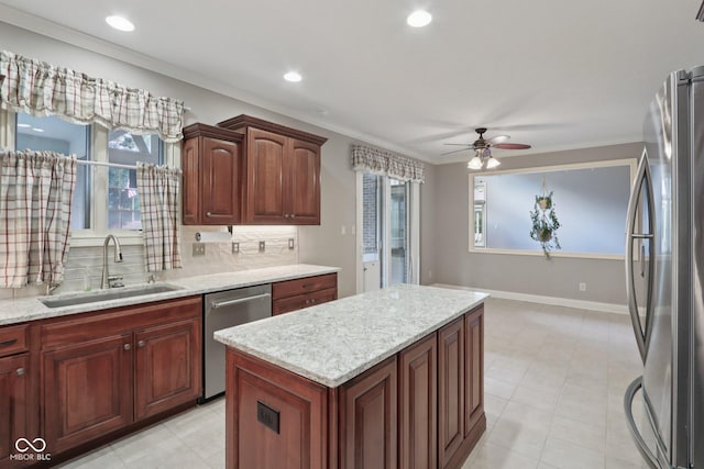 7927 Broadmead Way, Indianapolis, IN 46259 - kitchen with stainless steel appliances, ornamental molding, a ceiling fan, a kitchen island, and tasteful backsplash