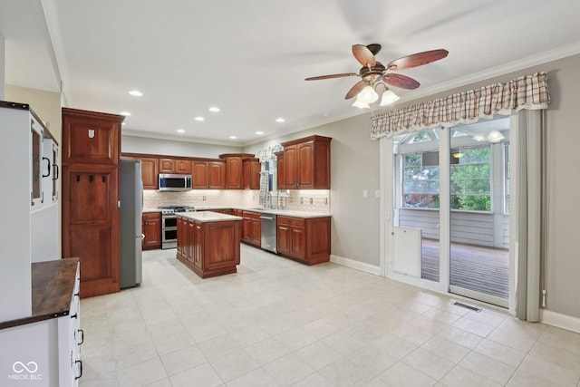 7927 Broadmead Way, Indianapolis, IN 46259 - kitchen with stainless steel appliances, ceiling fan, backsplash, ornamental molding, and a kitchen island