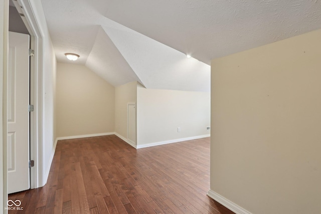 7927 Broadmead Way, Indianapolis, IN 46259 - additional living space featuring hardwood / wood-style flooring, vaulted ceiling, and a textured ceiling