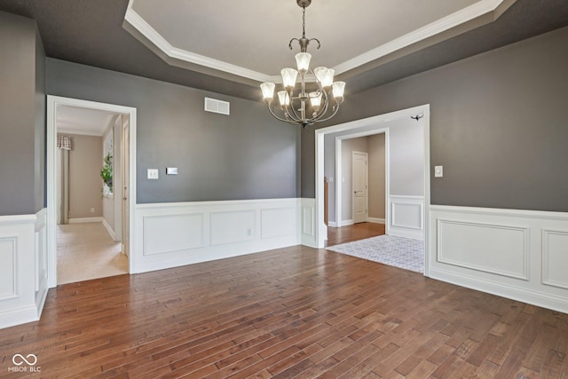 7927 Broadmead Way, Indianapolis, IN 46259 - spare room featuring a tray ceiling, a chandelier, crown molding, wood finished floors, and wainscoting