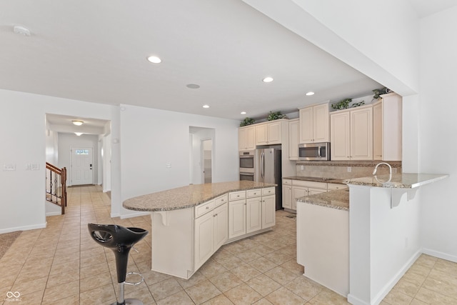 2833 Holiday Way, Greenwood, IN 46143 - kitchen featuring stainless steel appliances, a kitchen breakfast bar, light tile patterned floors, and recessed lighting