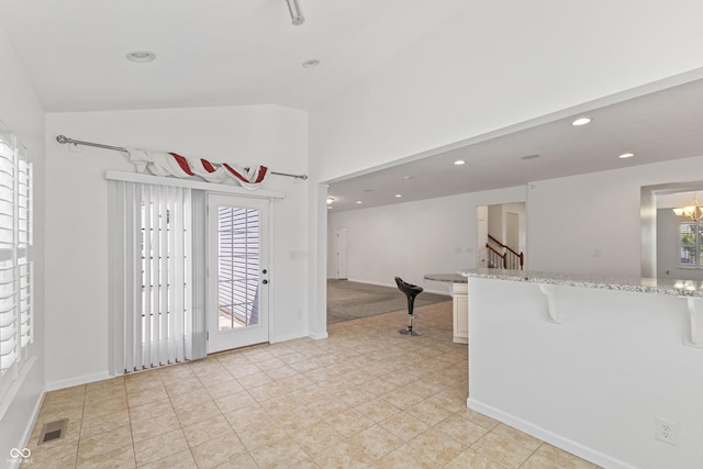 2833 Holiday Way, Greenwood, IN 46143 - kitchen featuring lofted ceiling, a kitchen bar, light stone counters, recessed lighting, and light tile patterned floors