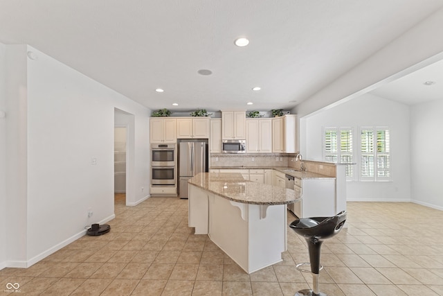 2833 Holiday Way, Greenwood, IN 46143 - kitchen featuring stainless steel appliances, a kitchen island, light stone countertops, a breakfast bar, and a peninsula