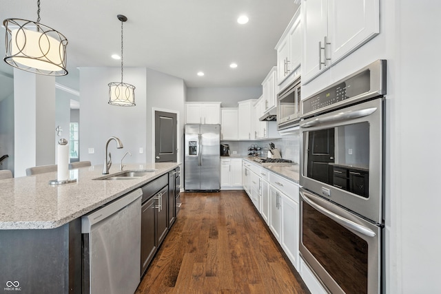 5875 Stroup Dr, Noblesville, IN 46062 - kitchen with appliances with stainless steel finishes, a center island with sink, white cabinetry, light stone counters, and recessed lighting