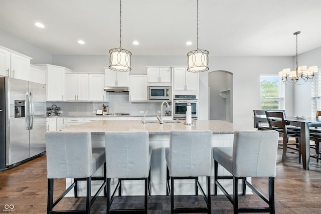 5875 Stroup Dr, Noblesville, IN 46062 - kitchen featuring stainless steel appliances, recessed lighting, backsplash, under cabinet range hood, and dark wood finished floors