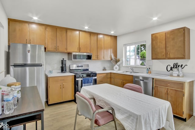 2149 Westline Dr, Columbus, IN 47203 - kitchen featuring stainless steel appliances, light countertops, decorative backsplash, light wood finished floors, and recessed lighting
