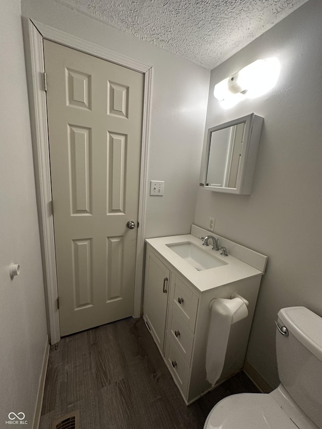 3708 Pleasant Creek Dr, Indianapolis, IN 46227 - half bathroom featuring vanity, a textured ceiling, and wood finished floors