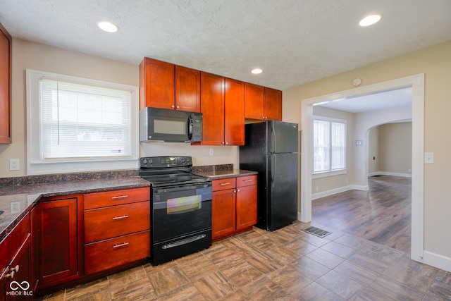 916 E 54th St, Indianapolis, IN 46220 - kitchen featuring black appliances, dark countertops, arched walkways, and recessed lighting