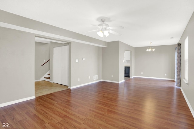 5422 Bluff View Dr, Indianapolis, IN 46217 - unfurnished living room with stairs, ceiling fan, wood finished floors, and a chandelier