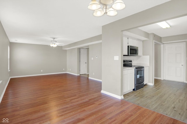 5422 Bluff View Dr, Indianapolis, IN 46217 - kitchen featuring stainless steel appliances, a ceiling fan, light wood-type flooring, white cabinets, and a chandelier
