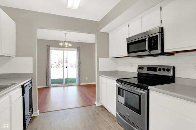 5422 Bluff View Dr, Indianapolis, IN 46217 - kitchen featuring stainless steel appliances, a chandelier, light wood-type flooring, and light countertops