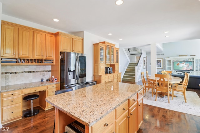 12068 Bayhill Dr, Carmel, IN 46033 - kitchen featuring stainless steel fridge with ice dispenser, dark wood-style floors, decorative backsplash, light stone counters, and a kitchen island