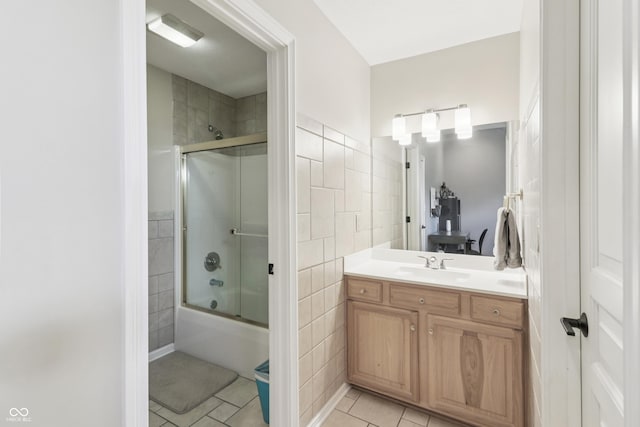 12068 Bayhill Dr, Carmel, IN 46033 - full bath with tile patterned floors, tile walls, vanity, and shower / bath combination with glass door