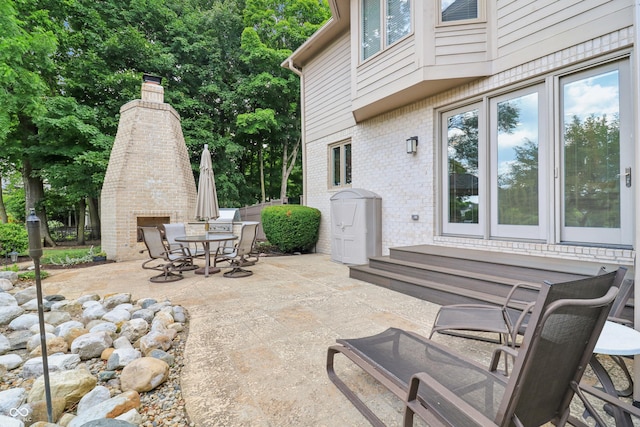12068 Bayhill Dr, Carmel, IN 46033 - view of patio / terrace featuring a fireplace, outdoor dining space, and entry steps
