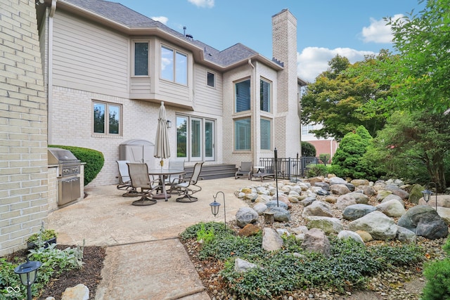 12068 Bayhill Dr, Carmel, IN 46033 - back of property with a chimney, a patio area, and brick siding