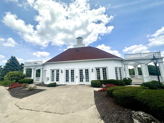 12068 Bayhill Dr, Carmel, IN 46033 - back of property featuring french doors, a balcony, driveway, and a shingled roof