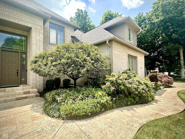 12068 Bayhill Dr, Carmel, IN 46033 - view of side of property with brick siding, roof with shingles, and entry steps