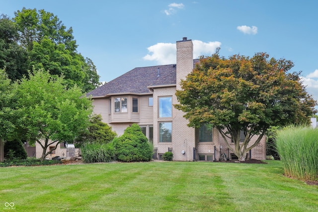 12068 Bayhill Dr, Carmel, IN 46033 - back of house with a lawn, a chimney, and brick siding