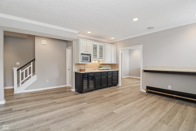12068 Bayhill Dr, Carmel, IN 46033 - kitchen with stainless steel microwave, light wood-style flooring, white cabinetry, recessed lighting, and decorative backsplash