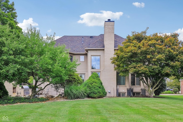 12068 Bayhill Dr, Carmel, IN 46033 - back of house with a yard, a chimney, and brick siding