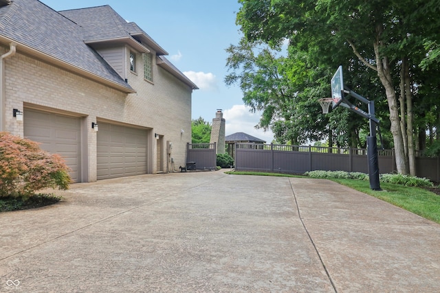 12068 Bayhill Dr, Carmel, IN 46033 - view of side of property with concrete driveway, brick siding, and roof with shingles