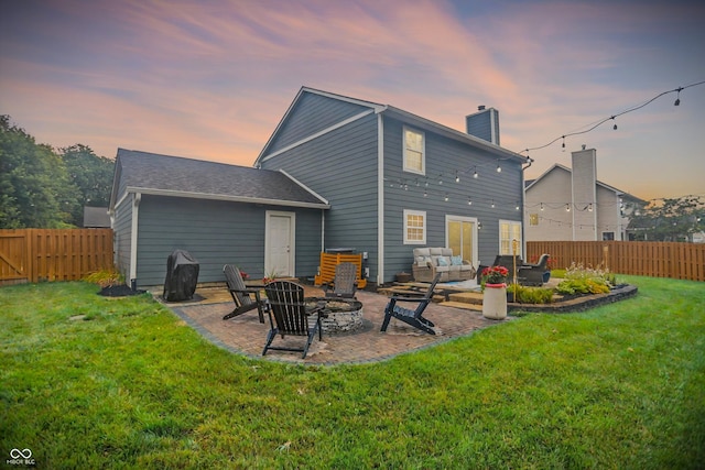 17101 Rushmore Dr, Westfield, IN 46074 - back of property at dusk with an outdoor living space with a fire pit, a chimney, a patio area, and a fenced backyard