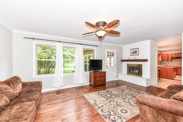 3012 Rollshore Ct, Carmel, IN 46033 - living area with a ceiling fan, light wood finished floors, a brick fireplace, and crown molding