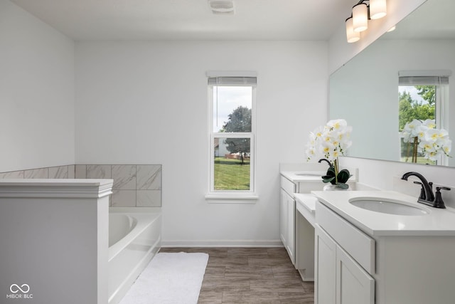 10524 Broadford St, Indianapolis, IN 46239 - full bathroom featuring plenty of natural light, double vanity, a bath, and wood finished floors