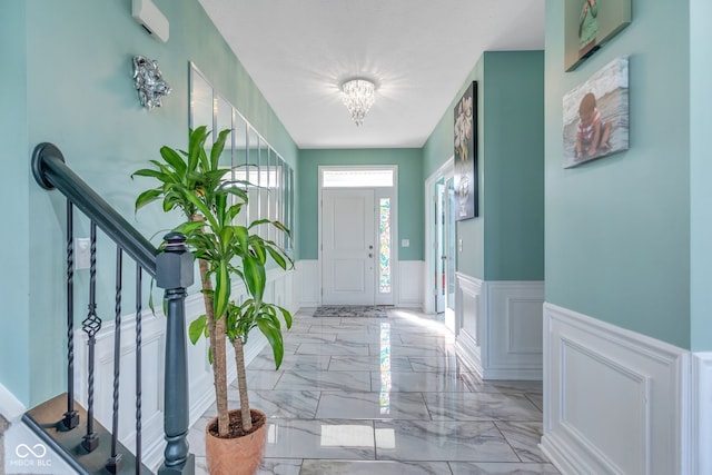1358 Avocet Dr, Greenwood, IN 46143 - foyer featuring a decorative wall, wainscoting, light marble finish flooring, stairs, and a chandelier