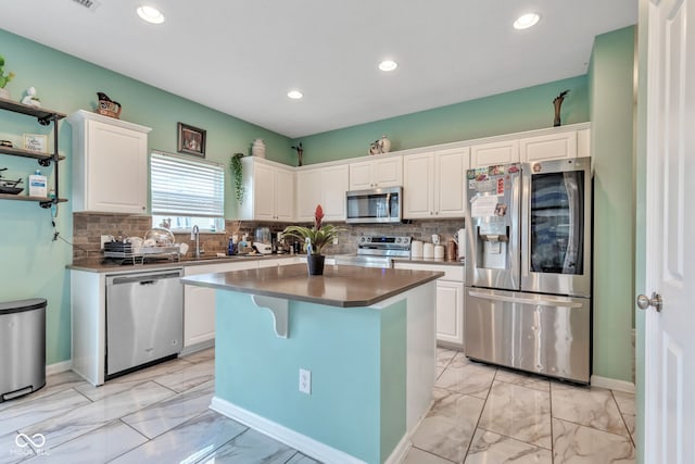 1358 Avocet Dr, Greenwood, IN 46143 - kitchen featuring appliances with stainless steel finishes, light marble finish floors, white cabinetry, recessed lighting, and backsplash