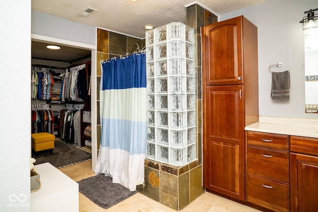 5322 Lily Pad Ln, Indianapolis, IN 46237 - full bathroom with a walk in shower, vanity, a textured ceiling, and a walk in closet