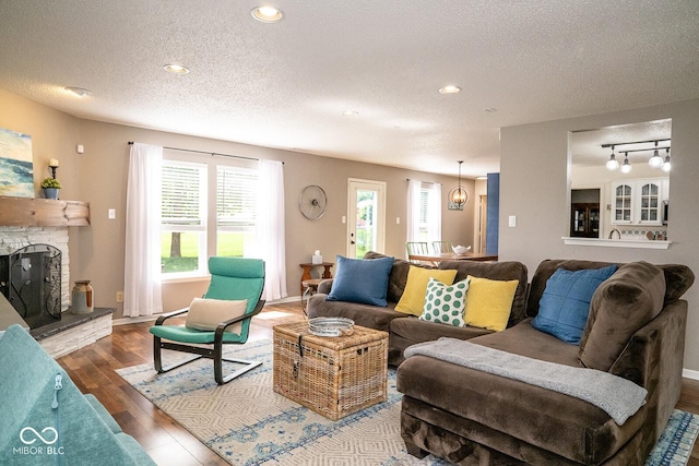 5322 Lily Pad Ln, Indianapolis, IN 46237 - living area with a textured ceiling, wood finished floors, a stone fireplace, and recessed lighting