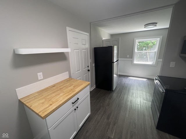 3119 N Fuller Dr, Indianapolis, IN 46224 - kitchen with freestanding refrigerator, black electric range, dark wood finished floors, butcher block countertops, and white cabinetry