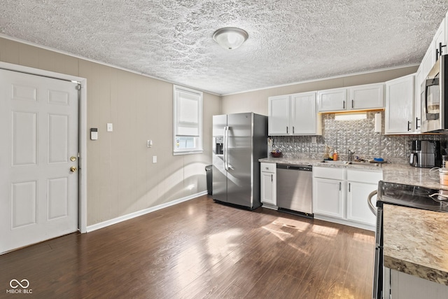 1418 S 7th St, Terre Haute, IN 47802 - kitchen featuring stainless steel appliances, dark wood-style flooring, white cabinets, backsplash, and light countertops