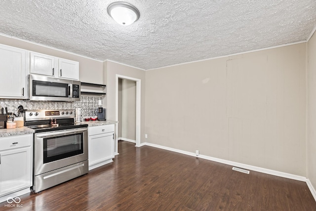 1418 S 7th St, Terre Haute, IN 47802 - kitchen featuring appliances with stainless steel finishes, decorative backsplash, dark wood-type flooring, a textured ceiling, and white cabinetry