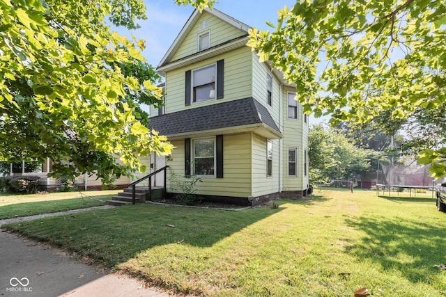 1418 S 7th St, Terre Haute, IN 47802 - view of front of home with a trampoline, roof with shingles, and a front lawn