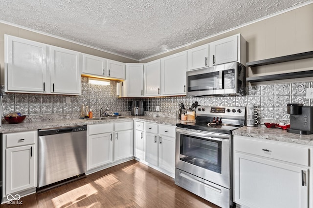 1418 S 7th St, Terre Haute, IN 47802 - kitchen with stainless steel appliances, a textured ceiling, white cabinetry, ornamental molding, and dark wood-type flooring