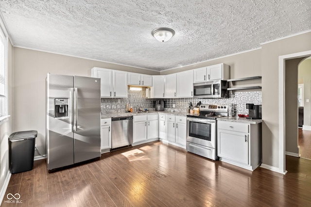 1418 S 7th St, Terre Haute, IN 47802 - kitchen with appliances with stainless steel finishes, crown molding, backsplash, white cabinets, and dark wood-style flooring