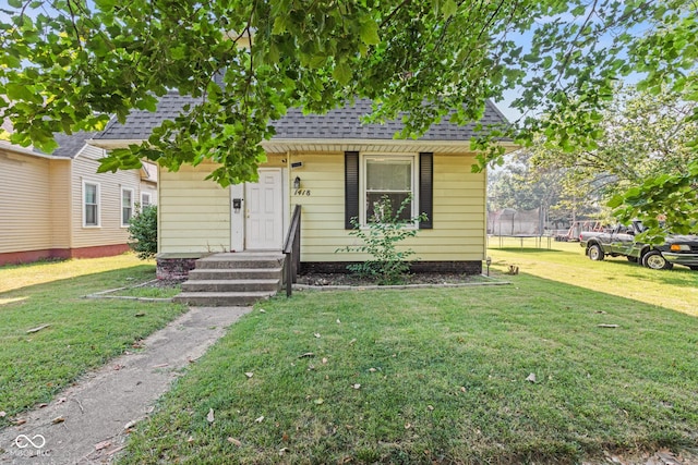 1418 S 7th St, Terre Haute, IN 47802 - view of front of property with a trampoline, a shingled roof, and a front yard