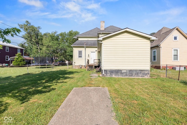1418 S 7th St, Terre Haute, IN 47802 - back of property with a trampoline, a fenced backyard, and a chimney