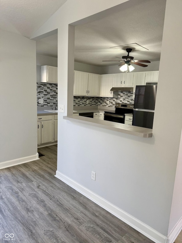 4024 Zinfandel Way, Indianapolis, IN 46254 - kitchen featuring stainless steel electric stove, freestanding refrigerator, a ceiling fan, decorative backsplash, and wood finished floors
