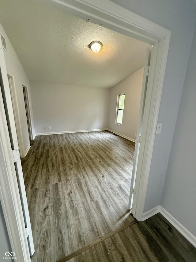4024 Zinfandel Way, Indianapolis, IN 46254 - empty room with wood finished floors, vaulted ceiling, and a textured ceiling